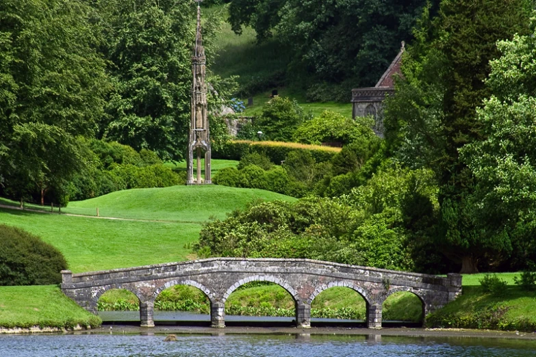 a bridge over a body of water surrounded by green trees