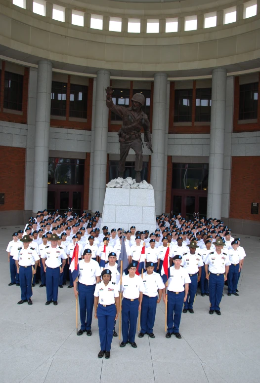 large group of uniformed people standing in front of a building