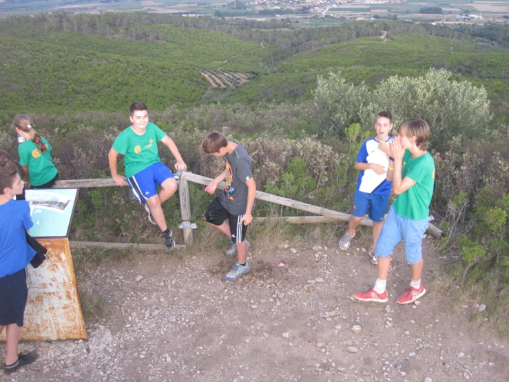 some young people looking at soing while standing on a hill