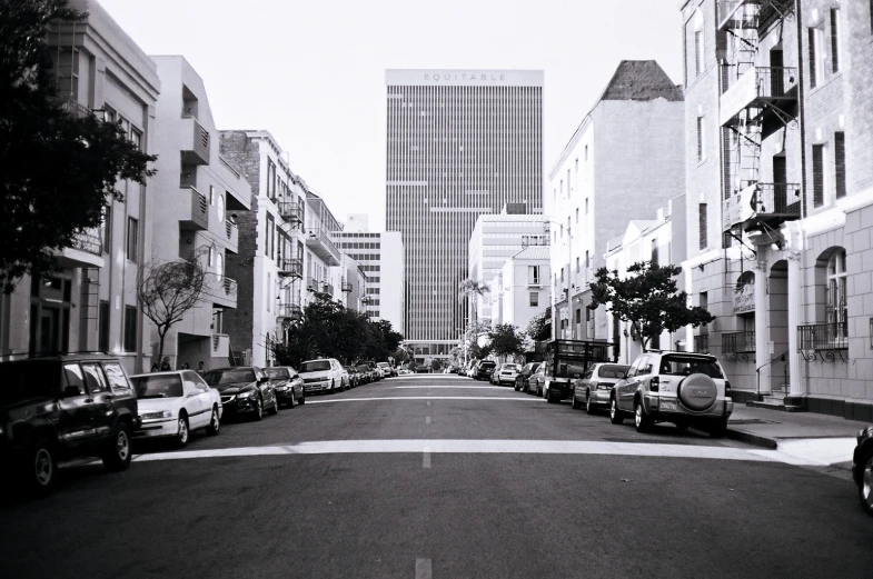 street lined with cars in black and white pograph