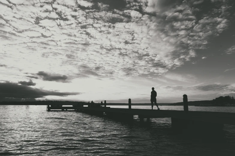 a man is standing on the end of a dock