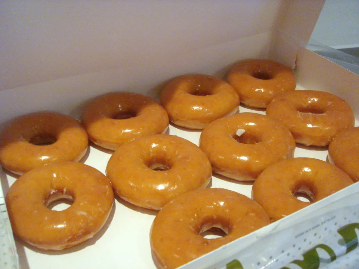 six glazed donuts sitting in an open box