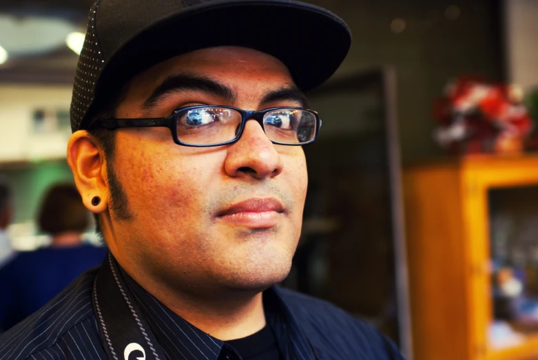 man in suit and hat in store wearing glasses