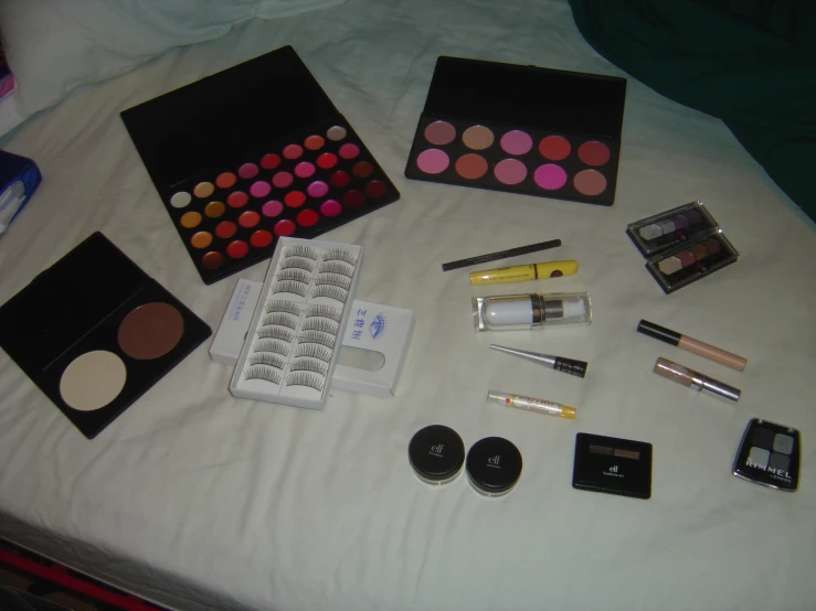 the contents of a beauty bag spread out on a bed