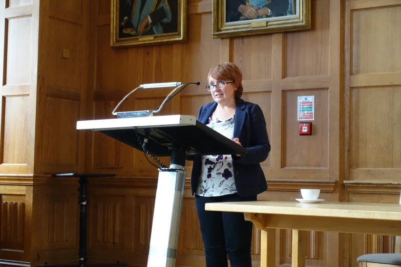 a woman is speaking on a podium at an event