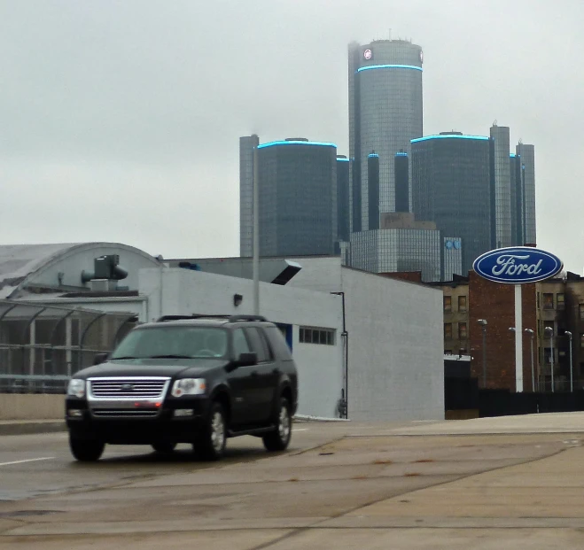 a ford suv drives past a car dealership on the road