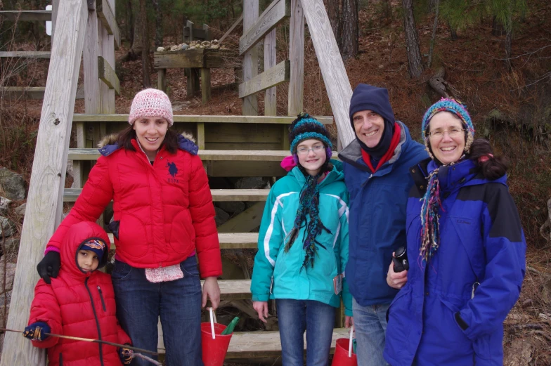 four people standing on the steps of a forest trail