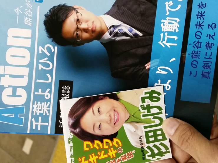 a person holding up a magazine with an asian cover