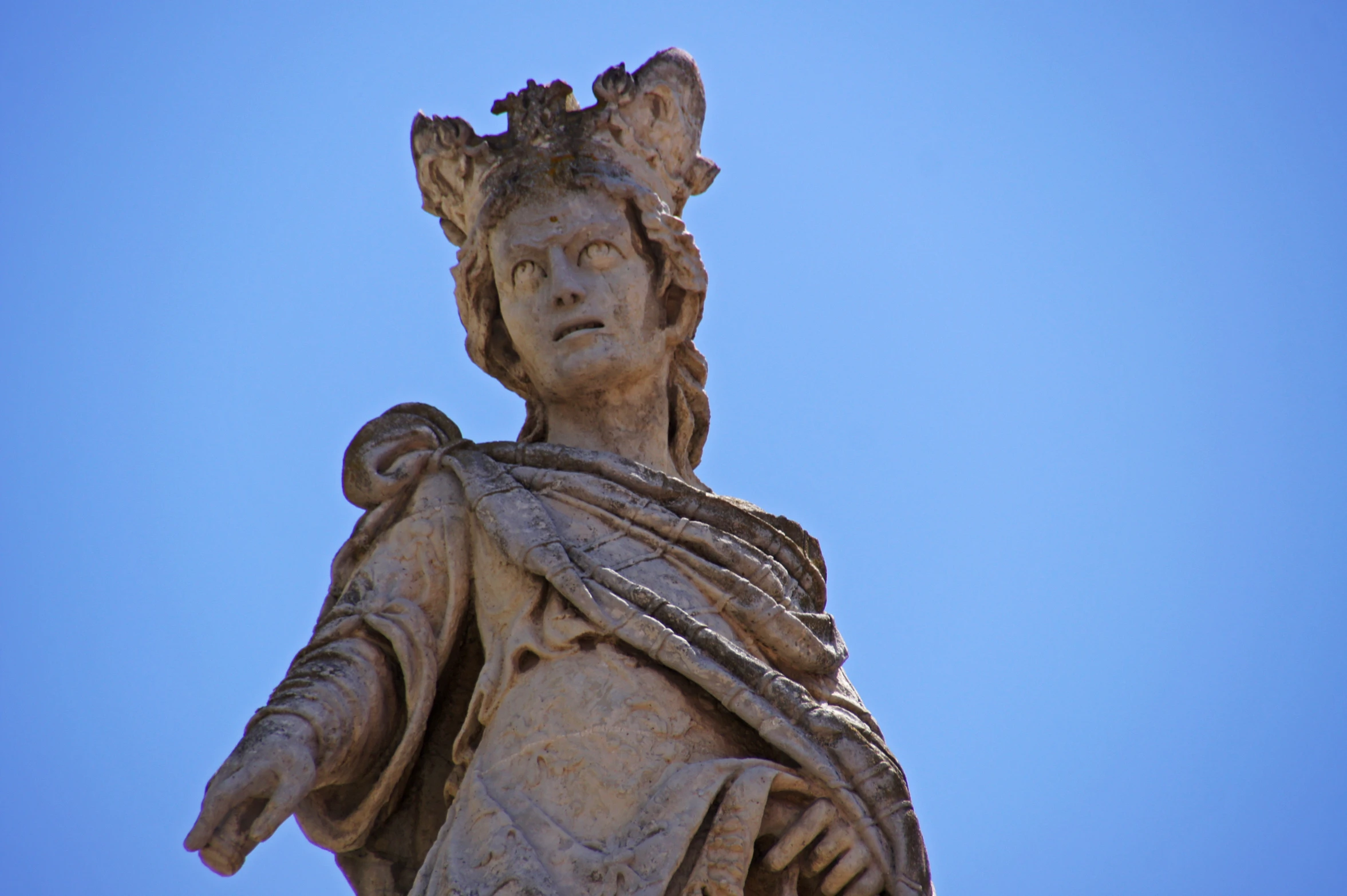 an ancient statue is shown against a blue sky