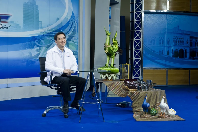 a man sitting on a chair in front of a television