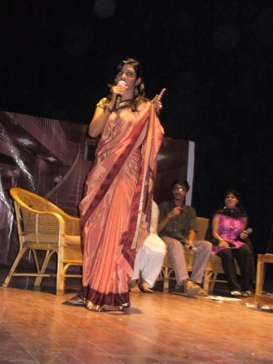 a woman standing on a stage holding a microphone