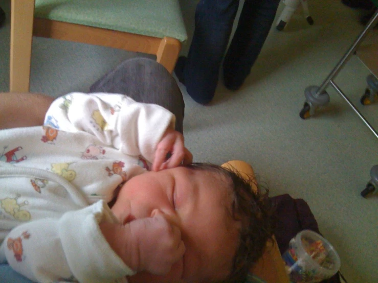 a young infant lays on the floor and smiles