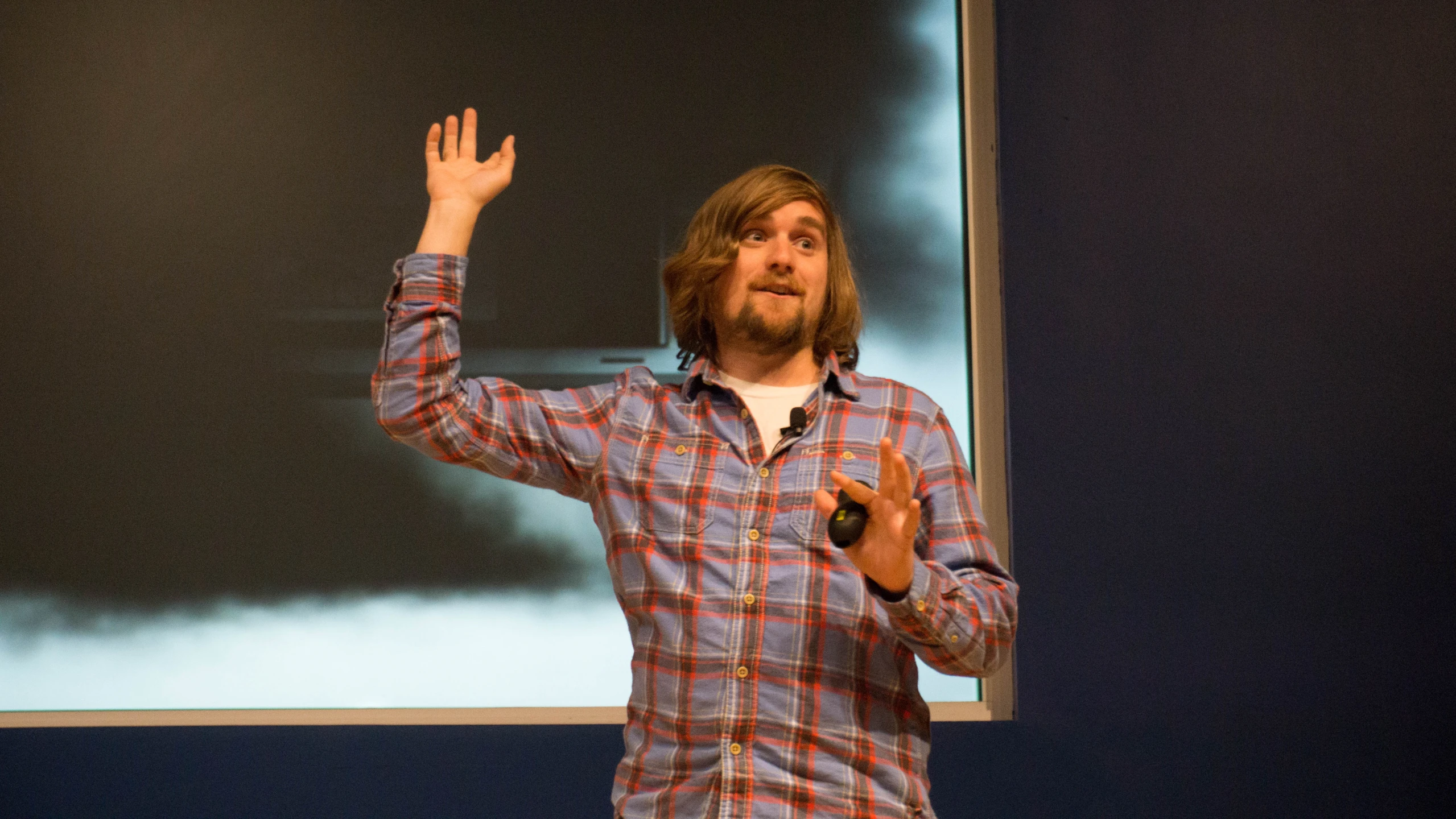 a man holding up his hand while making a speech