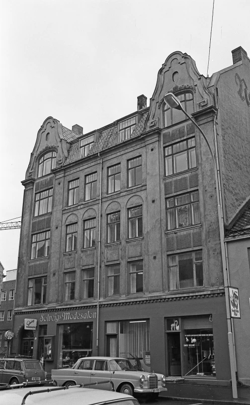 a black and white image of cars and buildings