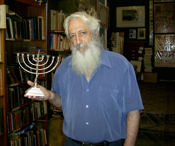a man standing in a room with a menorah
