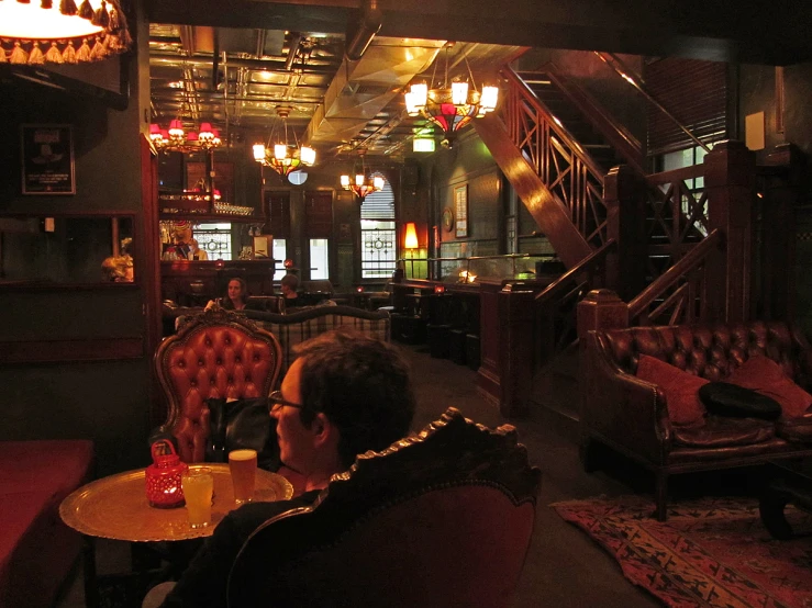 people at a dimly lit restaurant with lights on the ceiling