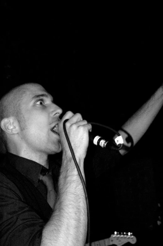 black and white pograph of a man singing into a microphone