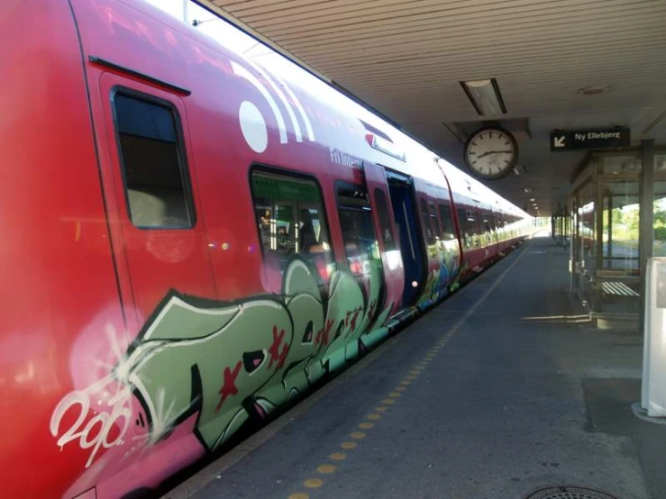 a red train that has some graffiti on it