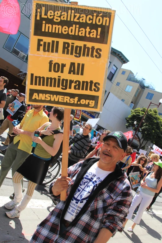 a man holding a sign in the middle of a crowded street