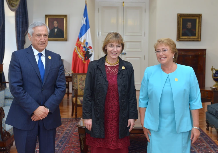 three people standing in a room with a few flags