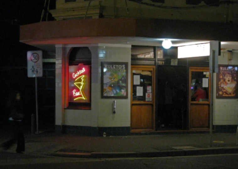 a person is walking outside a restaurant at night