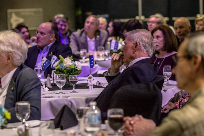 a group of people sitting around tables at a dinner