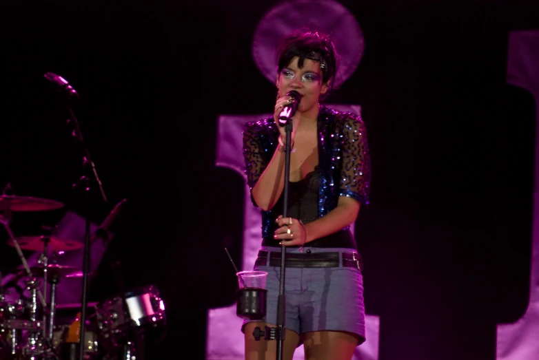 a woman on stage singing and holding a microphone