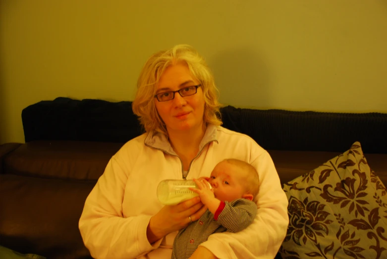 a woman with glasses holding a baby