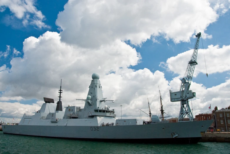 military type boat sailing through the water with a crane on top