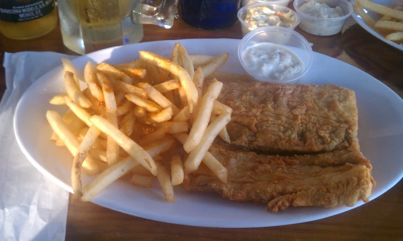 some fries and fish are sitting on a white plate