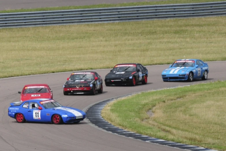 three race cars in a straight line on a track