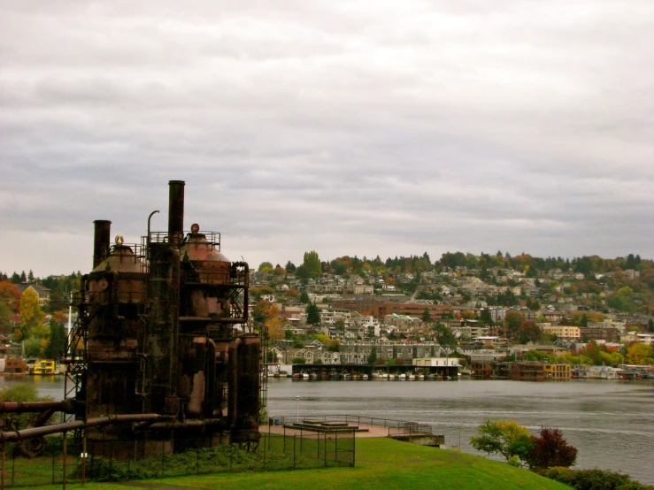 an old factory with pipes near a body of water