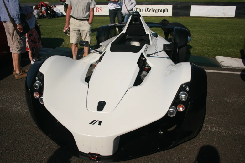 a close up of a racing car with people standing around it