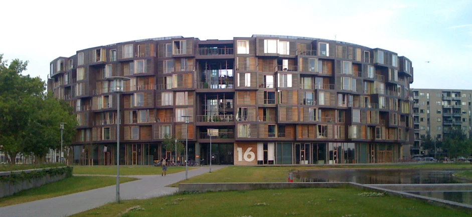 a building made out of many windows next to a body of water