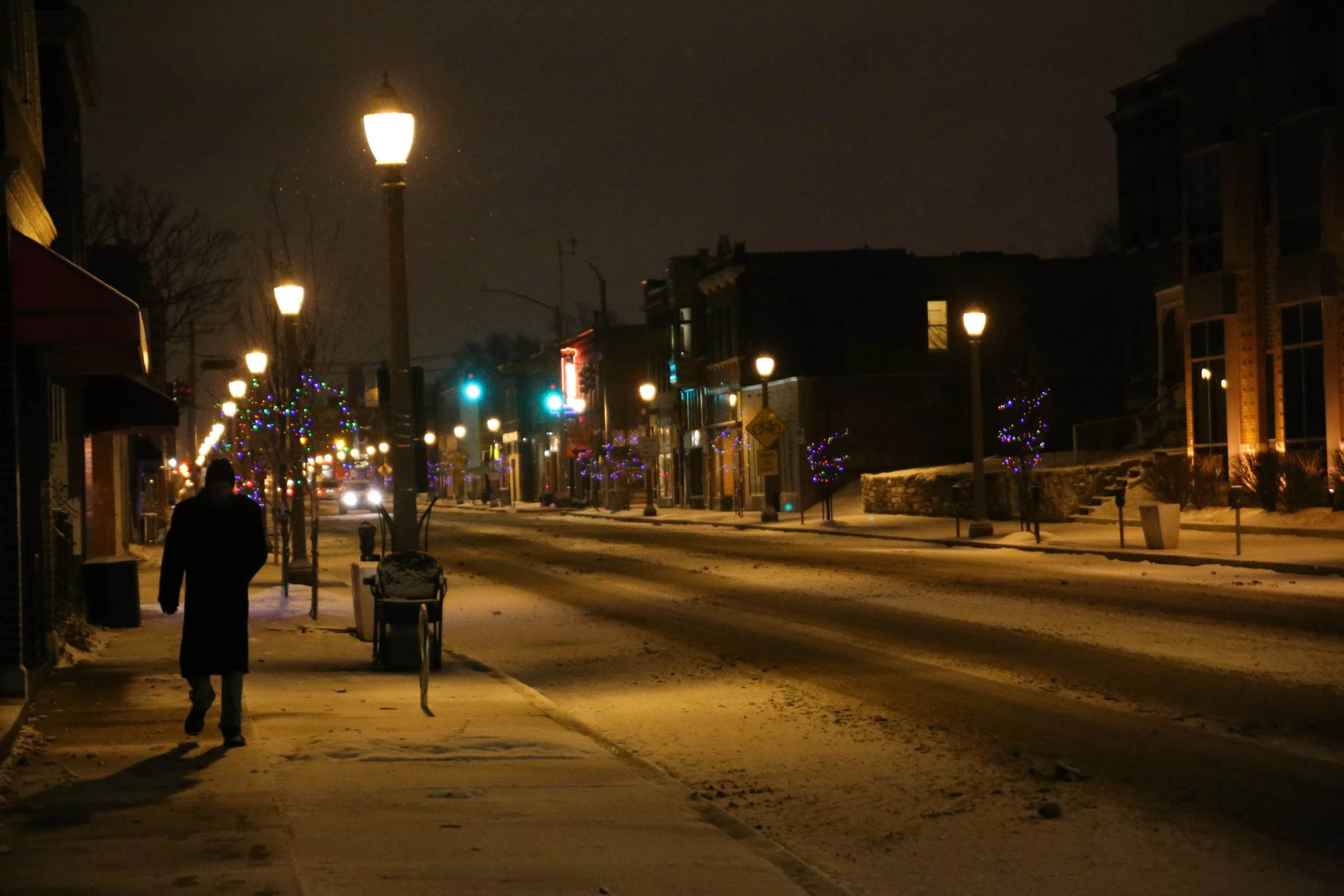 a person walking down a sidewalk at night