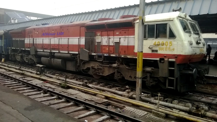 the train is pulling into the station with workers nearby