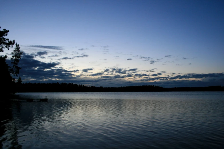 a body of water sitting under a cloudy sky