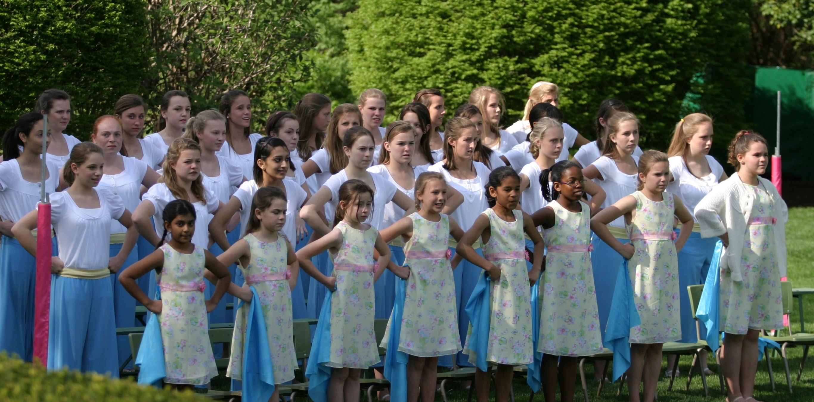 a group of children choir with adults and children in dresses