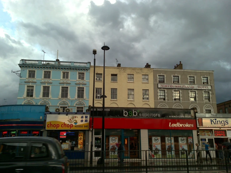 two tall buildings under a cloudy sky next to street lights