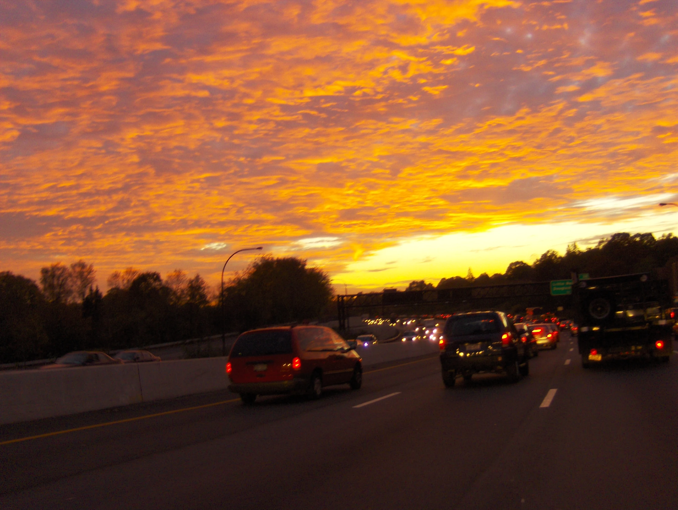 the cars are traveling down the road with sunset