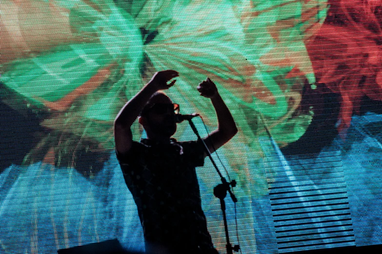 a close - up of a person on stage with their hand in the air while performing