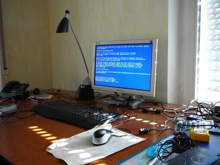 a desk with two computers and multiple cords