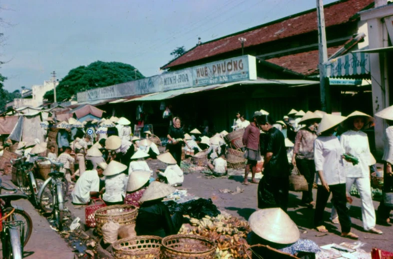 a group of people stand outside a village store selling goods