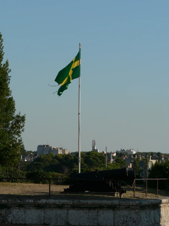 a flag flying above a field next to a large building