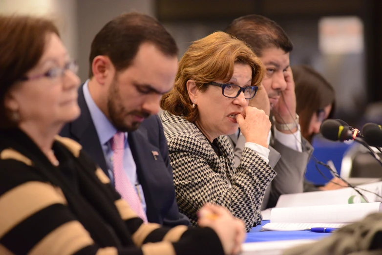 four people in business attire at a public meeting