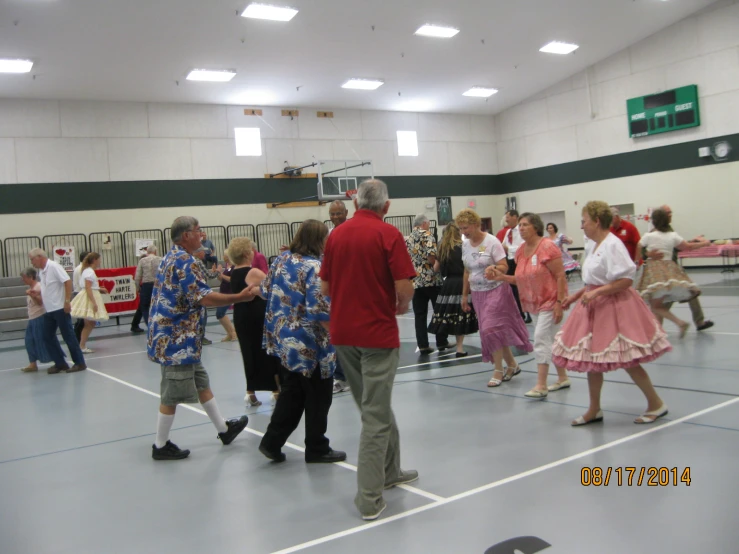 a group of people dancing in an indoor gym