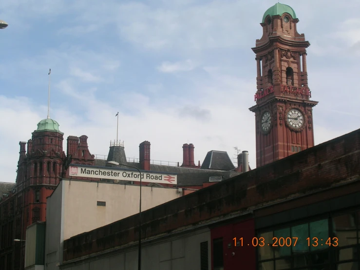 a big clock tower with many chimneys in the city