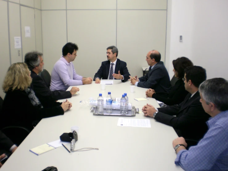 a group of men and women sitting around a conference table