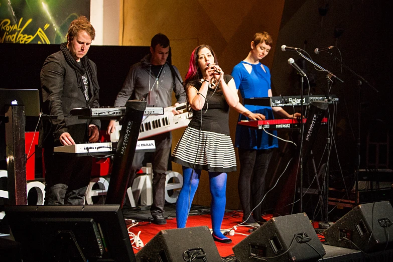 a band with the music director standing in front of a microphone