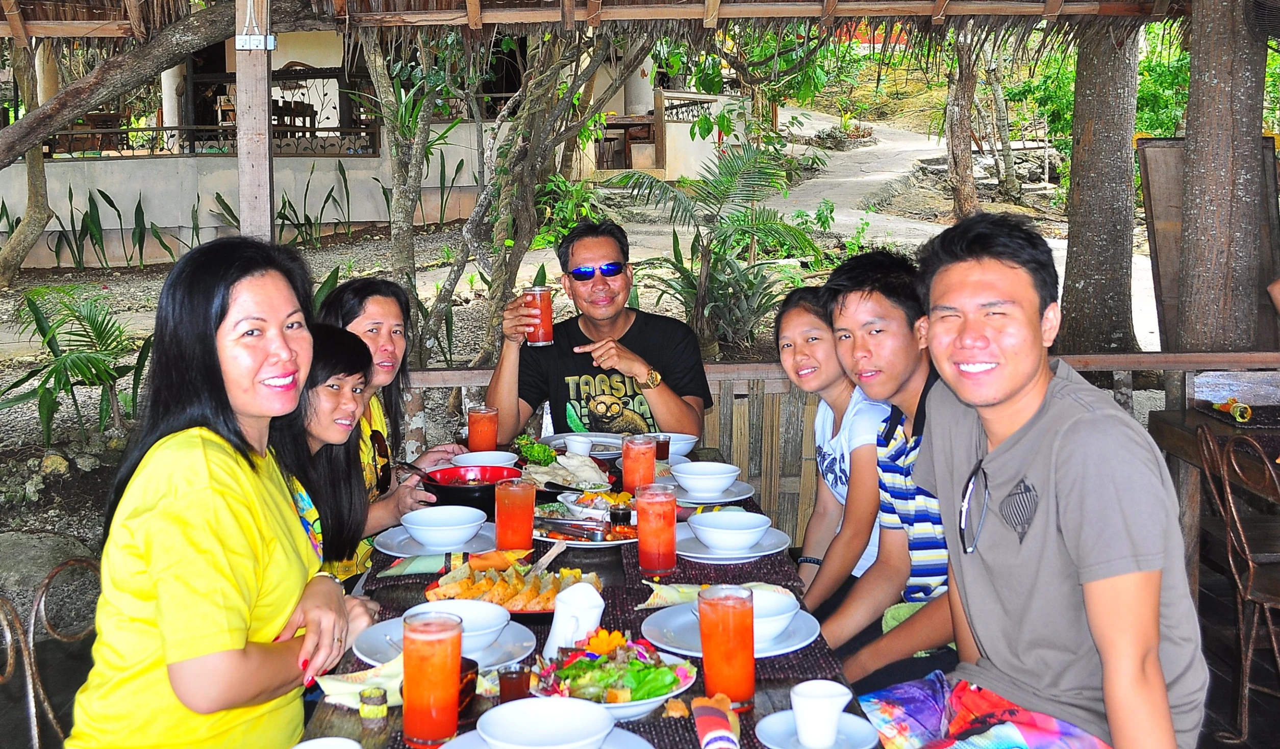 a group of people sitting at a dinner table with plates of food